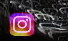 The Instagram logo amid a swirl of blurred white lights on a black background. 