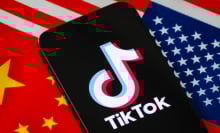 a tiktok logo on a phone with the american and chinese flags behind it