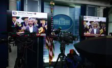 Two monitors in the White House press room show a screenshot of a post by President Trump sharing an AI edited video of House Minority Leader Hakeem Jeffries.