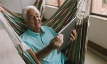 Man looking at laptop from hammock