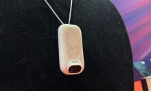 white wearable AI device on black background