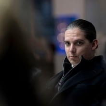 Starbuck sits at a conference table. 