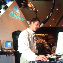 Under a giant AOL logo, a man looks at a 1990s computer. 