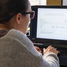 woman working on job resume on laptop