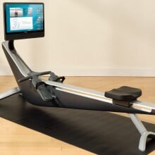 the Hydrow Arc rower on a black mat in a living room