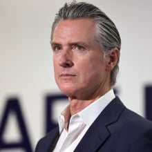 California Gavin Newsom, in profile, looks toward an audience. 