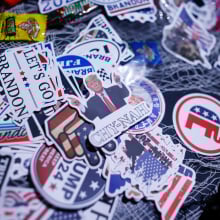 A pile of stickers featuring Trump memes, "Let's Go Brandon" messages, and Republican symbols. 
