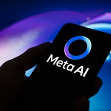 A hand holding a phone with the Meta AI logo.