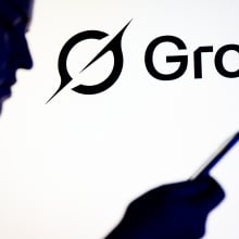 A silhouette of a person reading on a phone in front of the Grok logo.