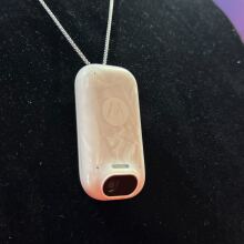 white wearable AI device on black background