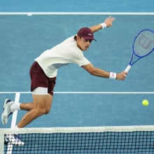 Alex de Minaur plays a backhand in the Australian Open