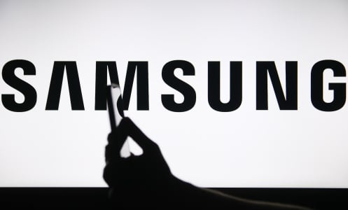 The Samsung logo displays on a screen with a person holding a phone