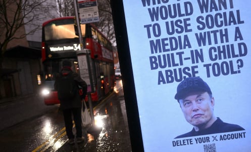 A sign next to bus stop in London reads "Who the hell would want to use social media with a built-in child abuse tool?" and a photo of Elon Musk.