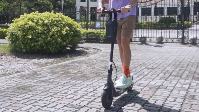 Black electric scooter with person on it in park