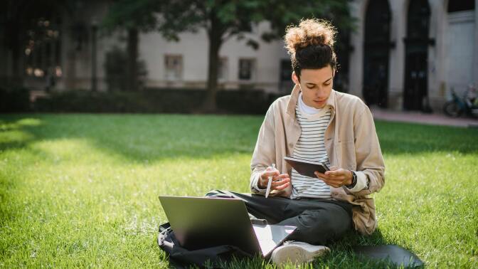 Man on grass with laptop