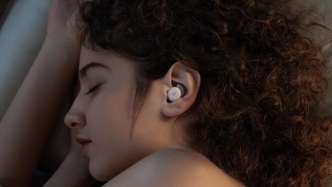 a person sleeps on their side while wearing the soundcore sleep a20 earbuds