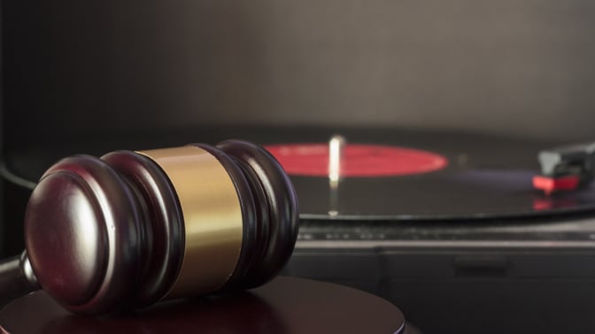 Judge's gavel in front of a vinyl record
