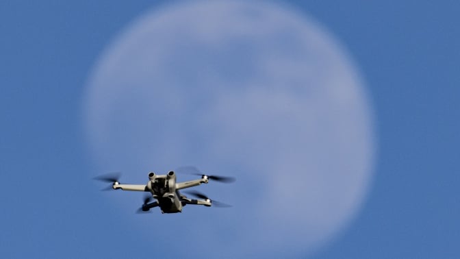 A drone in front of the moon