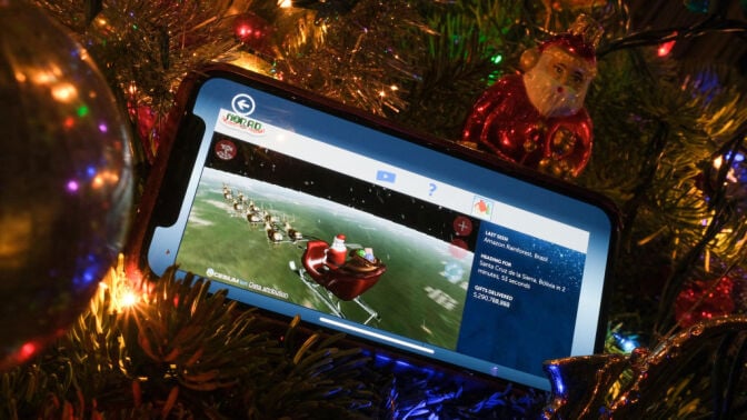 NORAD Tracks Santa app on a smartphone in a christmas tree 