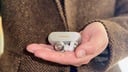 close-up of man holding panasonic technics az100 earbuds in hand