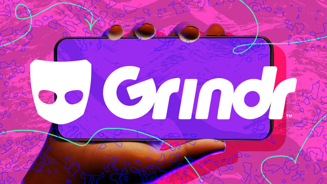Hand holding phone with Grindr logo against abstract background