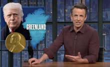 A man sits behind a talk show desk. An image of the president is in the top-left.