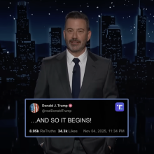 A man in a suit stands on a talk show stage. At the bottom of the screen is a Truth Social post from Donald Trump reading "...AND SO IT BEGINS."