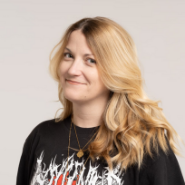 A photo portrait of a journalist with blonde hair and a band t-shirt.
