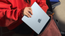 a close-up of a woman placing a 13-inch m4 apple macbook air into a backpack