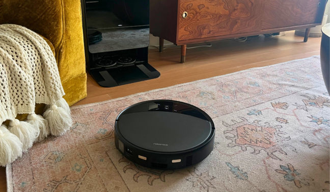 Roborock Saros 10R robot vacuum cleaning rug with living room furniture in peripherals