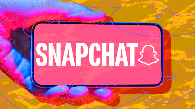 Hand holding phone with Snapchat logo against abstract background